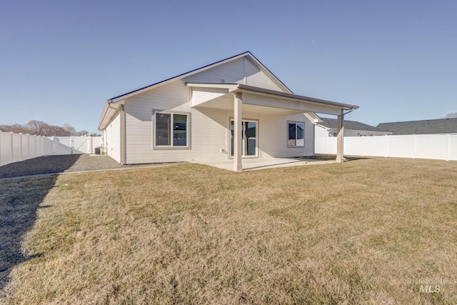 rear view of house featuring a yard and a patio area