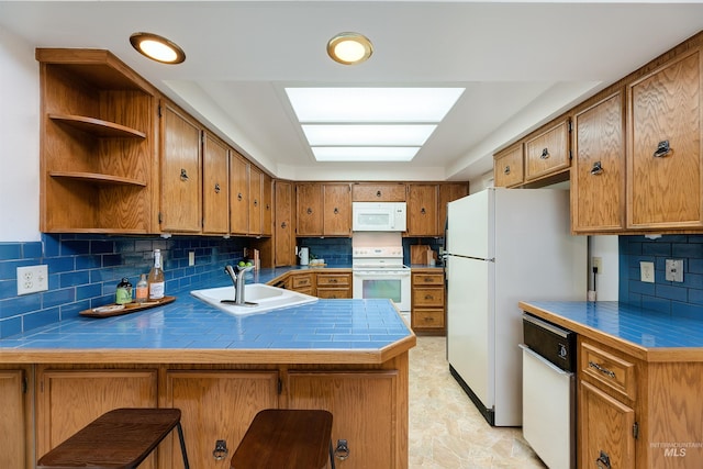 1574 E Sendero Ln, Boise, ID 83712 - kitchen featuring white appliances, a sink, a peninsula, brown cabinetry, and tasteful backsplash