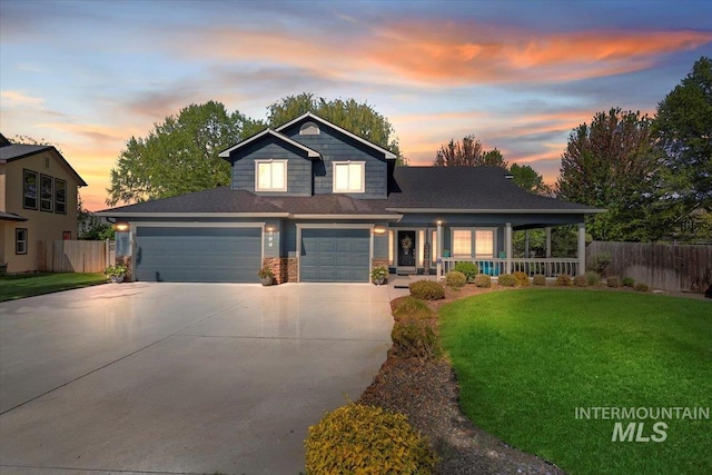 view of front facade with fence, covered porch, driveway, and a front yard