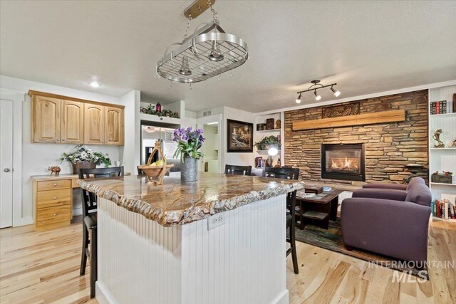 kitchen with light wood-style floors, light brown cabinets, and a breakfast bar area
