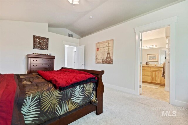 bedroom with visible vents, lofted ceiling, light carpet, baseboards, and connected bathroom