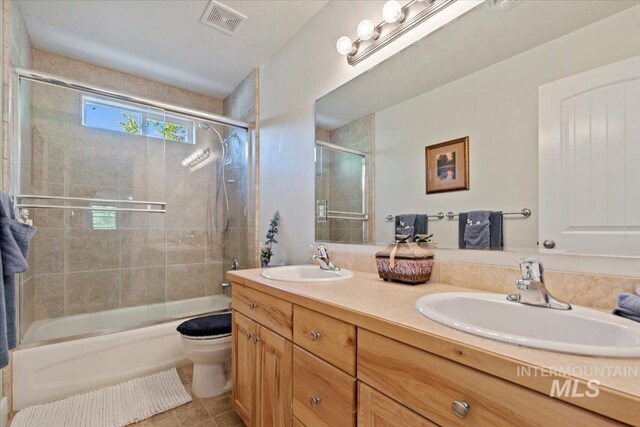 bathroom featuring visible vents, a sink, double vanity, and toilet