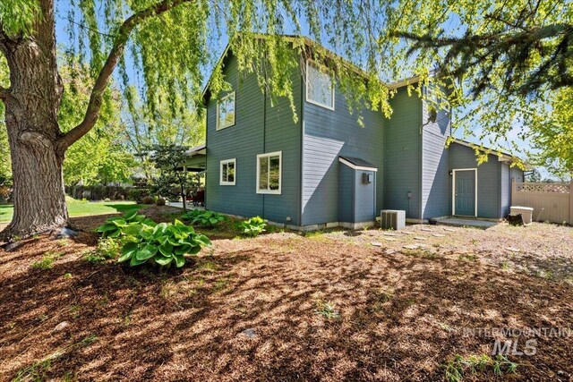 back of property with central AC and fence