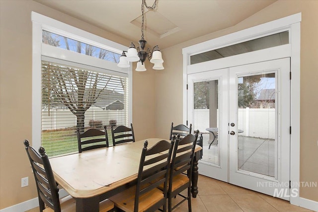 tiled dining space with a chandelier and french doors