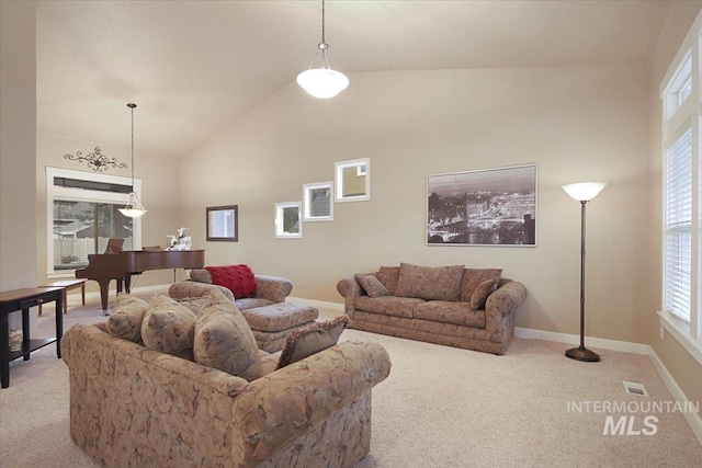 carpeted living room with plenty of natural light and high vaulted ceiling