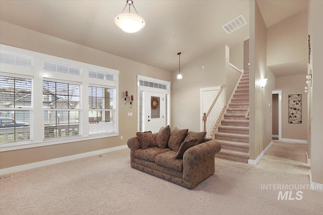 carpeted living room featuring high vaulted ceiling