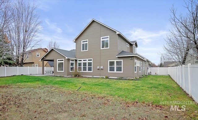 rear view of house with a lawn and a patio