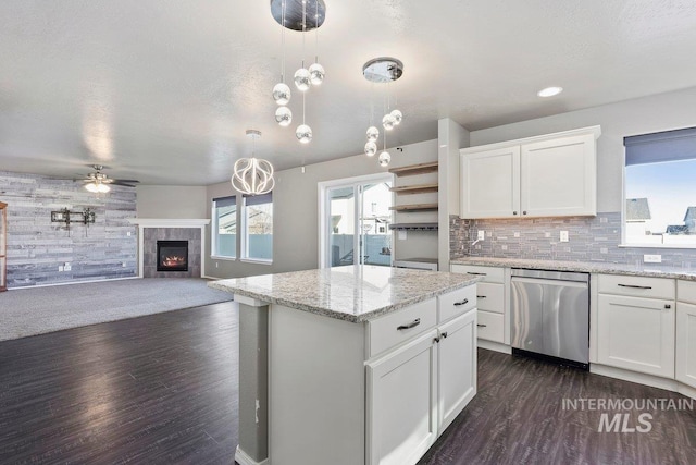 kitchen with a fireplace, pendant lighting, dishwasher, white cabinets, and dark hardwood / wood-style floors