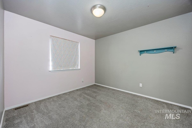 carpeted spare room featuring a textured ceiling