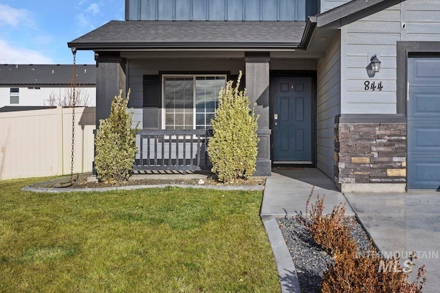 property entrance featuring a yard and covered porch