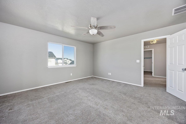 spare room featuring carpet flooring, ceiling fan, and a textured ceiling