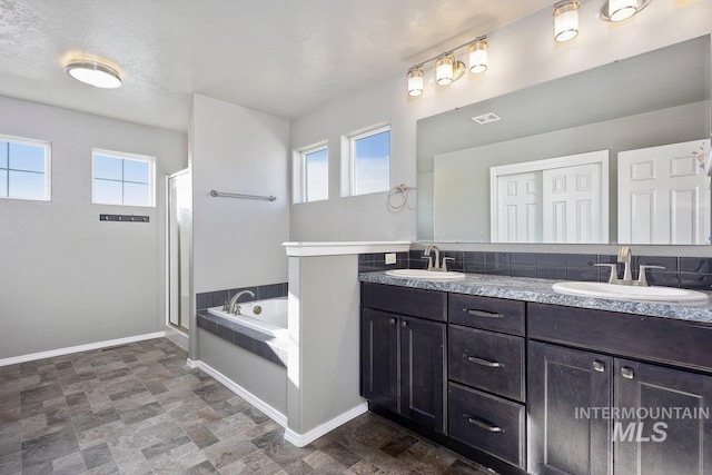 bathroom featuring a healthy amount of sunlight, vanity, and independent shower and bath