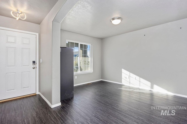 foyer featuring a textured ceiling and dark hardwood / wood-style floors