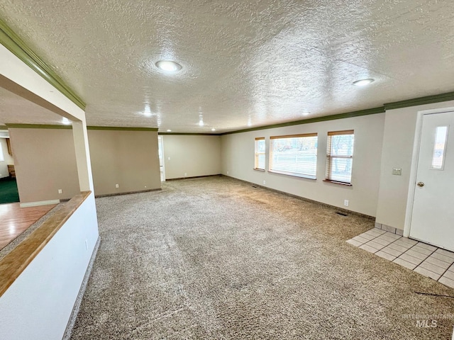 interior space featuring baseboards, a textured ceiling, ornamental molding, and carpet flooring