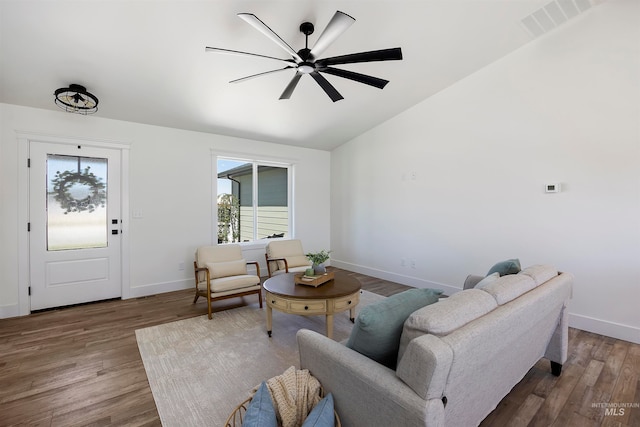 living room with hardwood / wood-style flooring, ceiling fan, and vaulted ceiling