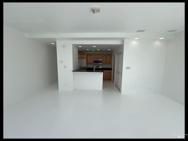 199 N Capitol Blvd, Boise, ID 83702 - kitchen featuring appliances with stainless steel finishes, dark countertops, recessed lighting, concrete flooring, and a peninsula