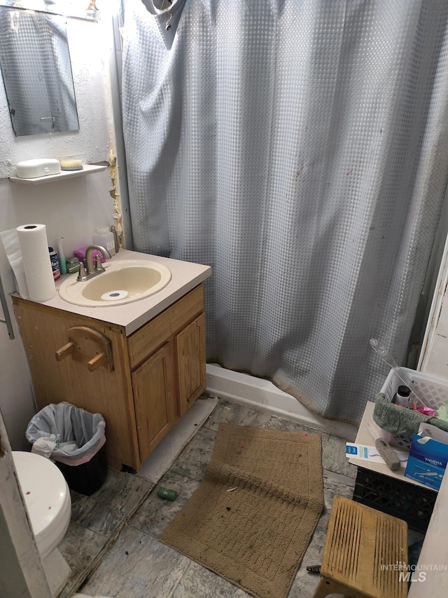 full bath featuring toilet, vanity, and a shower with curtain