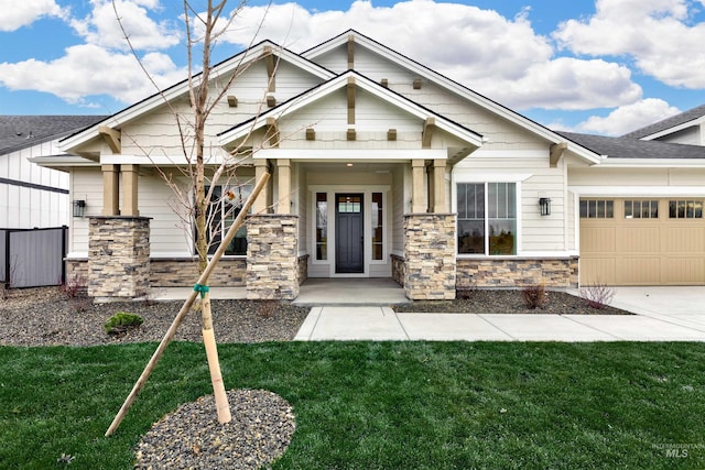 craftsman-style home featuring a front yard, an attached garage, stone siding, and concrete driveway