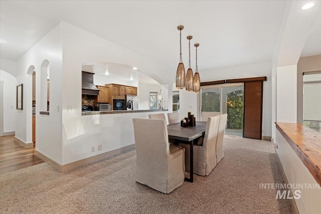 dining space featuring recessed lighting, arched walkways, and baseboards