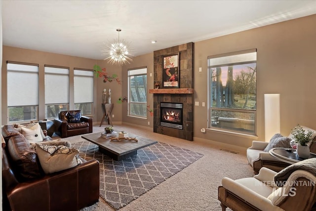 carpeted living room featuring a tiled fireplace, visible vents, baseboards, and a chandelier