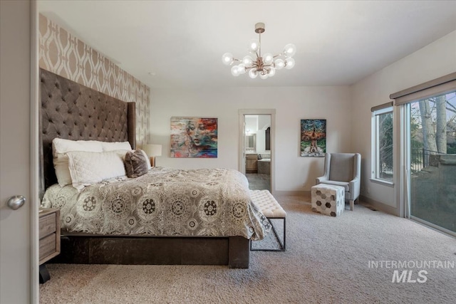 carpeted bedroom featuring access to exterior, baseboards, ensuite bathroom, and a chandelier