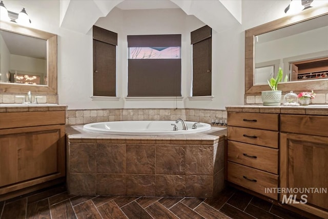 bathroom with vanity and a garden tub