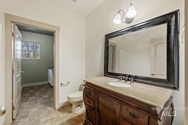 bathroom with visible vents, toilet, vanity, and baseboards