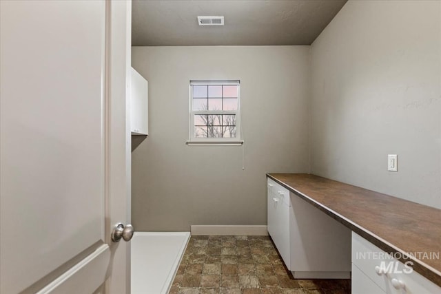 washroom featuring visible vents, stone finish floor, and baseboards