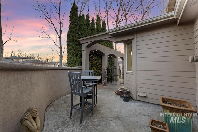 patio terrace at dusk featuring a gate