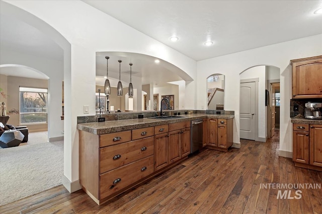 kitchen featuring a sink, open floor plan, brown cabinets, stainless steel dishwasher, and dark wood-style flooring