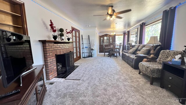 carpeted living room with a textured ceiling, a brick fireplace, and ceiling fan