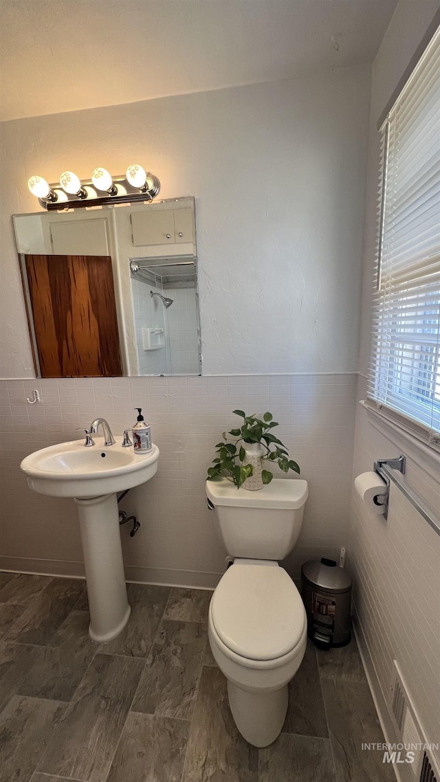 bathroom featuring tile walls, toilet, and tile patterned flooring