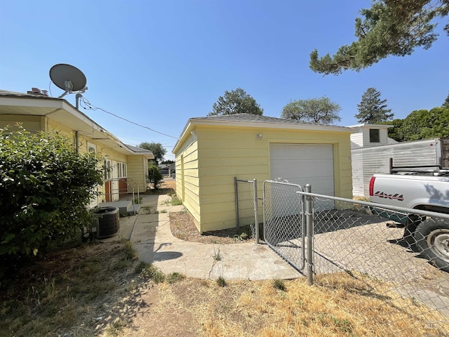 exterior space featuring central air condition unit and a garage