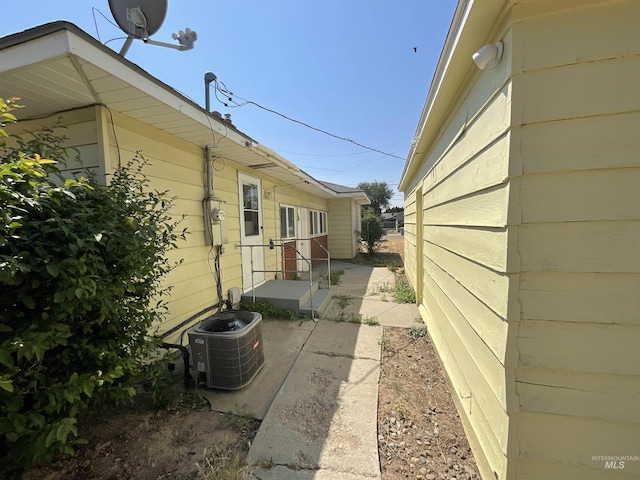 view of side of property with cooling unit and a patio area