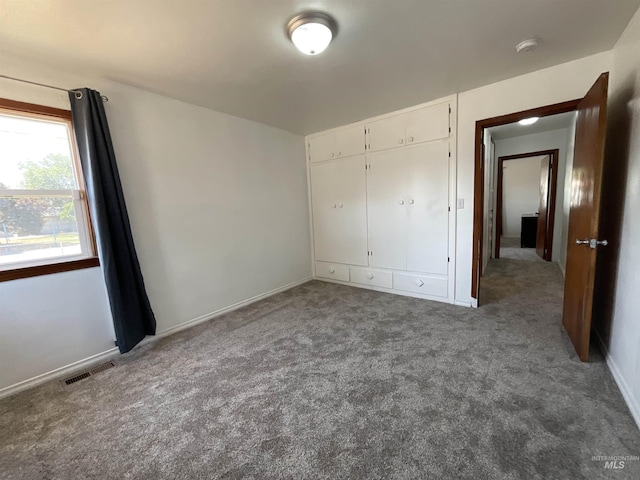 unfurnished bedroom with a closet and carpet flooring