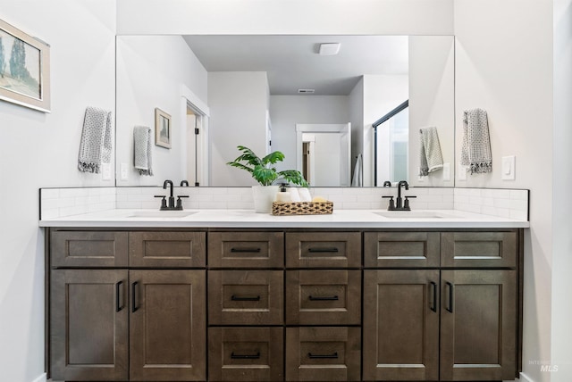 bathroom featuring double vanity, tasteful backsplash, and a sink