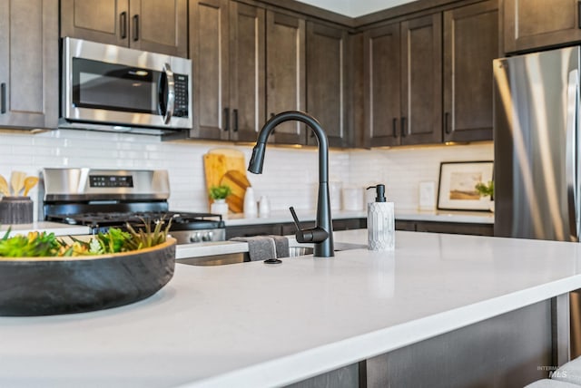 kitchen with stainless steel appliances, dark brown cabinetry, and decorative backsplash