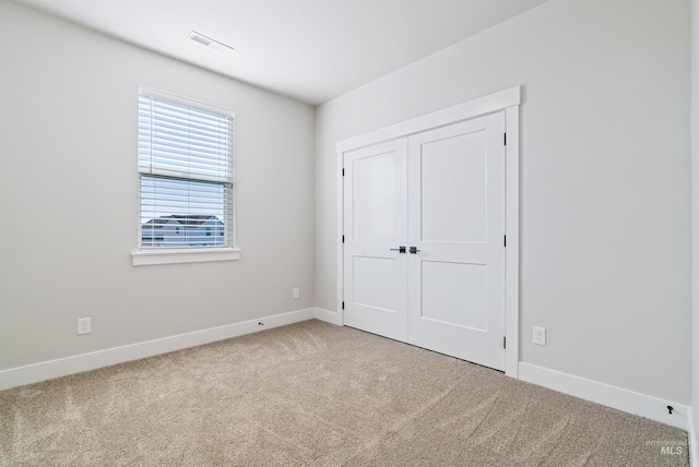 unfurnished bedroom with a closet, baseboards, visible vents, and carpet floors