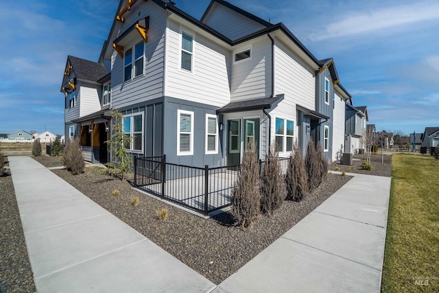 view of side of property with cooling unit, a residential view, and fence