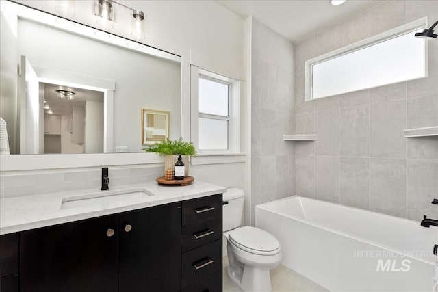 full bathroom featuring tile patterned floors, tiled shower / bath, vanity, and toilet