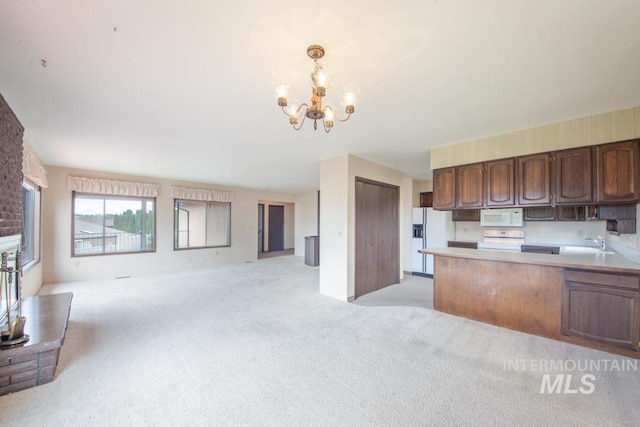 2634 Laurel Ct, Clarkston, WA 99403 - kitchen with white appliances, open floor plan, light colored carpet, a chandelier, and light countertops