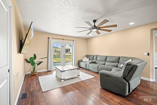 living room with ceiling fan, a textured ceiling, dark hardwood / wood-style floors, and french doors