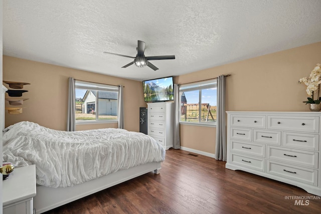 bedroom featuring ceiling fan, a textured ceiling, and dark hardwood / wood-style flooring