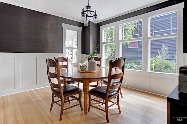 312 4th Ave, Lewiston, ID 83501 - dining space featuring a decorative wall, a chandelier, light wood-style floors, and crown molding