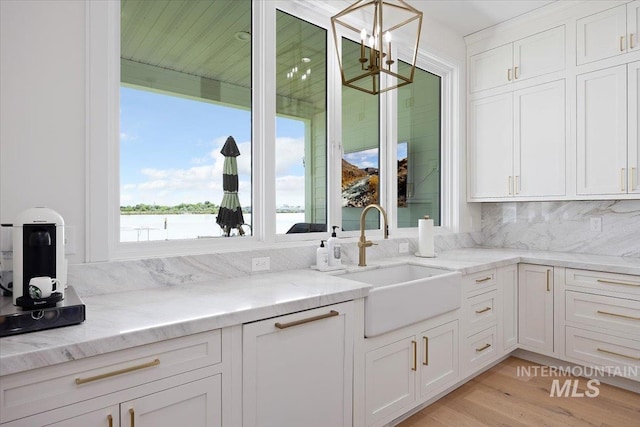 8 River Run Ests, Burley, ID 83318 - kitchen featuring a sink, a chandelier, white cabinetry, tasteful backsplash, and light stone counters