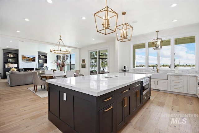 8 River Run Ests, Burley, ID 83318 - kitchen with a chandelier, white cabinets, a sink, a center island, and light stone counters