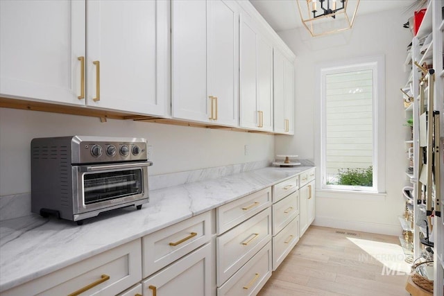 8 River Run Ests, Burley, ID 83318 - kitchen featuring light wood-type flooring, white cabinetry, and light stone counters