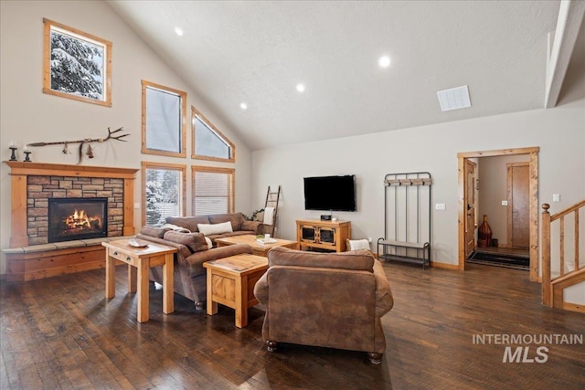 living room featuring a fireplace, a textured ceiling, dark hardwood / wood-style floors, and high vaulted ceiling