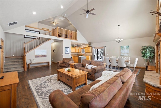 living room featuring ceiling fan with notable chandelier, dark hardwood / wood-style floors, and high vaulted ceiling