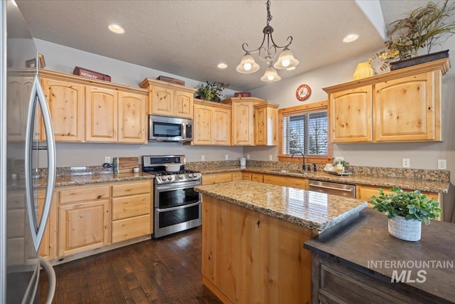 kitchen featuring light stone countertops, sink, hanging light fixtures, stainless steel appliances, and dark hardwood / wood-style floors